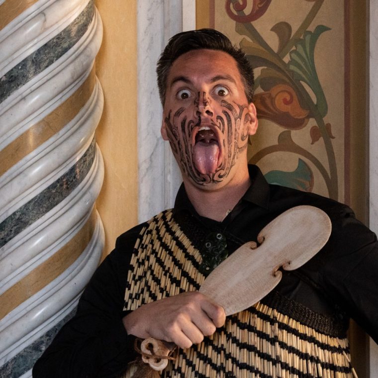 David Jones performing pukana and whetero while holding a kotiate