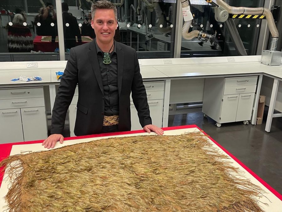 David Jones beside a feathered kahu huruhuru laid out in a museum conservation laboratory