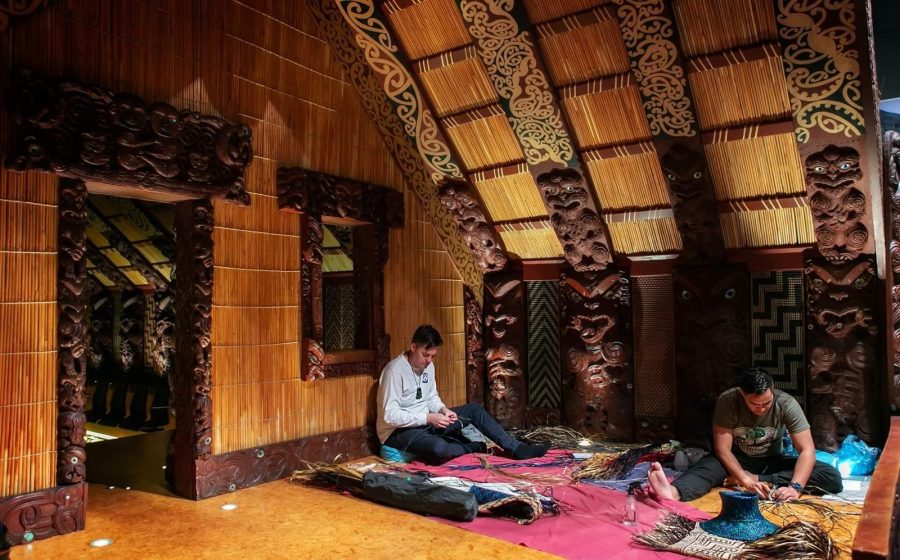Weaving harakeke inside a carved wharenui